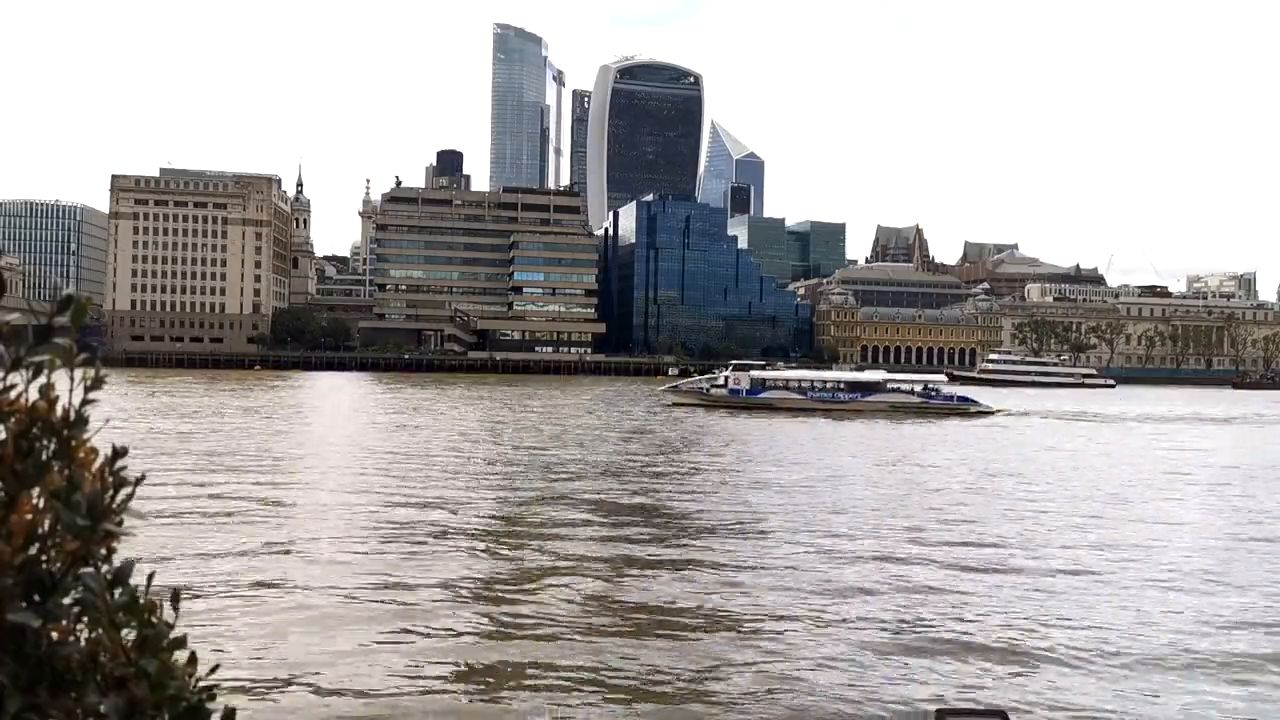 Office towers of the City of London rising behind buildings on the north bank of the Thames